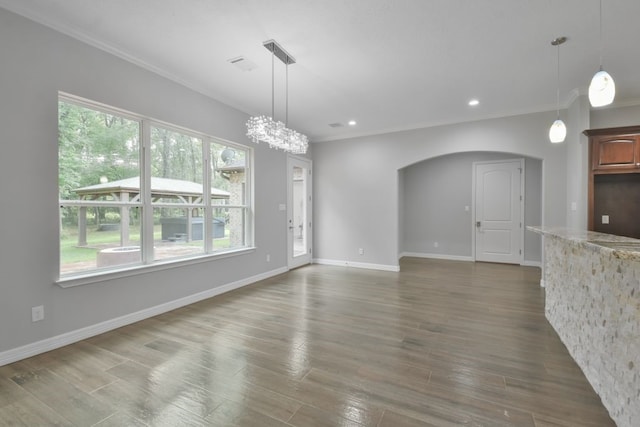 unfurnished dining area with an inviting chandelier, crown molding, and wood-type flooring