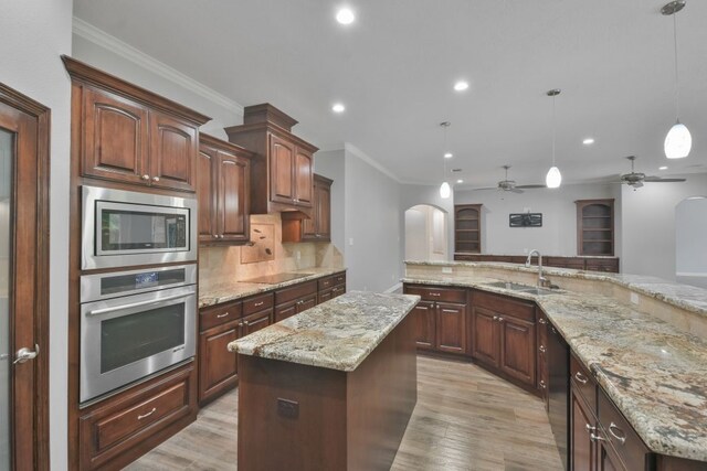 kitchen with light hardwood / wood-style flooring, a kitchen island, tasteful backsplash, ceiling fan, and black appliances