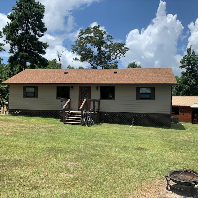 view of front of house with a fire pit and a front yard