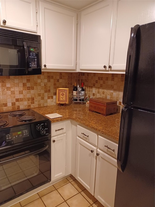 kitchen with white cabinetry, dark stone countertops, and black appliances