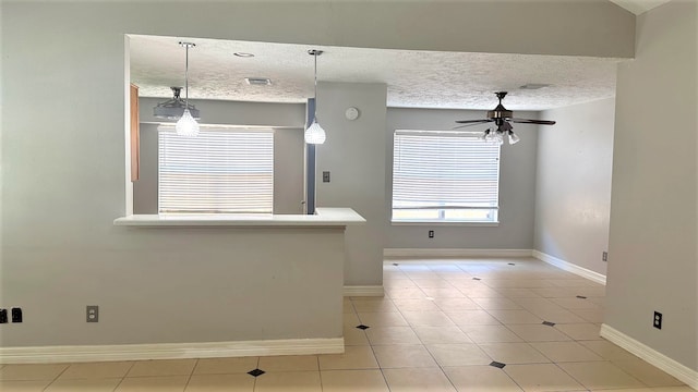 interior space with pendant lighting, light tile patterned floors, a textured ceiling, and ceiling fan