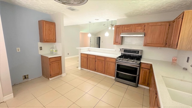 kitchen featuring lofted ceiling, light tile patterned floors, kitchen peninsula, hanging light fixtures, and stainless steel range with gas stovetop