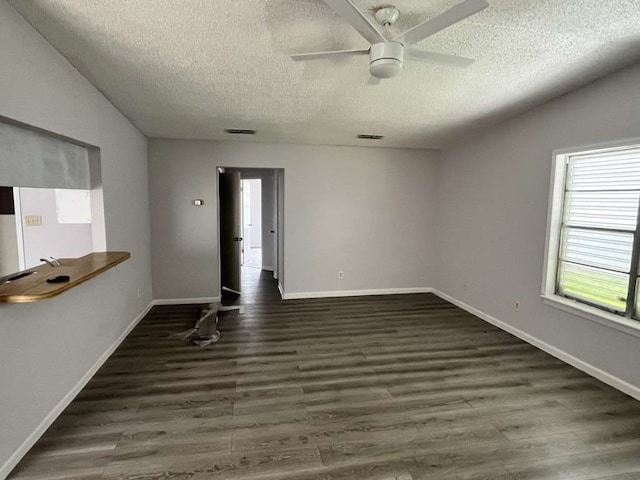 spare room featuring a textured ceiling, dark hardwood / wood-style floors, ceiling fan, and vaulted ceiling