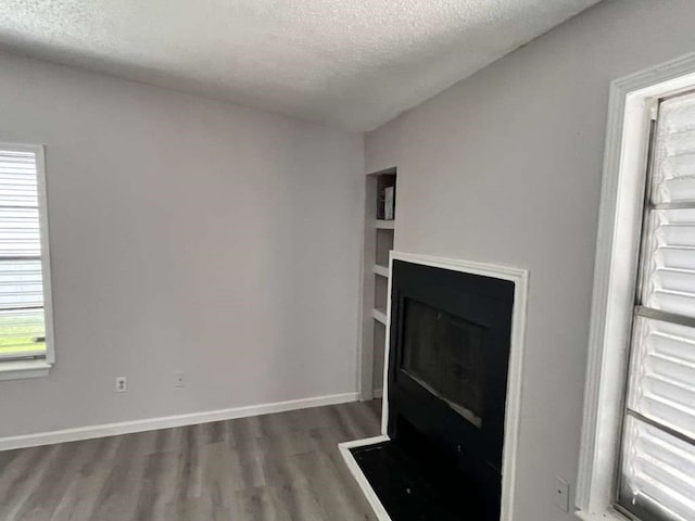 unfurnished living room featuring dark hardwood / wood-style floors and a textured ceiling