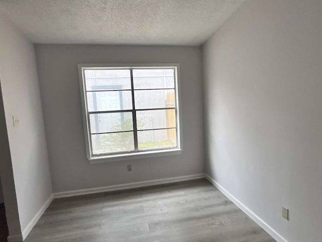 spare room featuring a textured ceiling and wood-type flooring