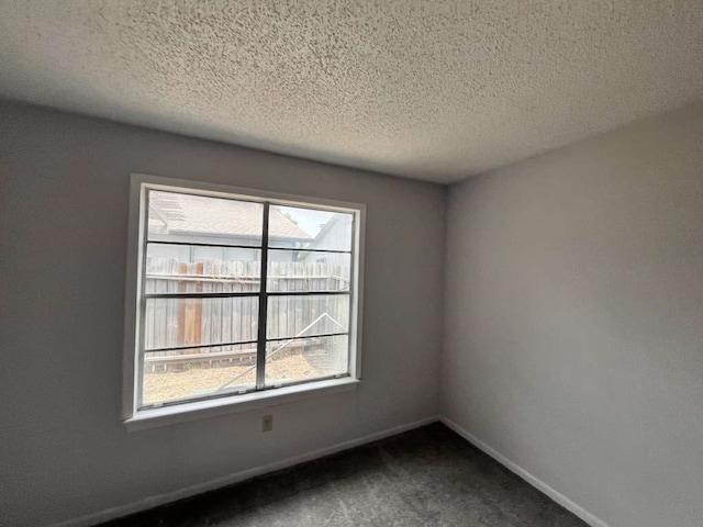 carpeted spare room with a textured ceiling