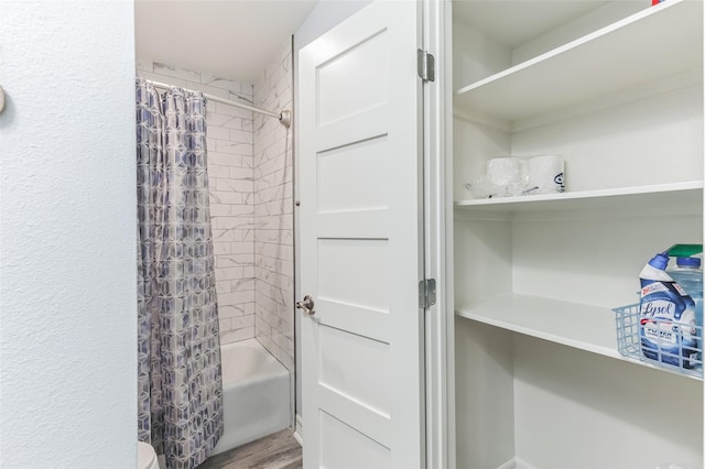 bathroom with wood finished floors and shower / bath combination with curtain