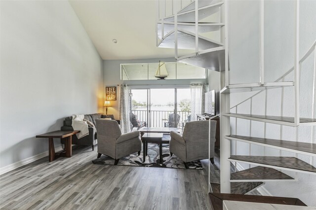 living room with high vaulted ceiling and hardwood / wood-style floors