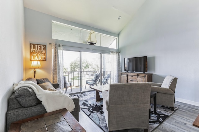 living room with high vaulted ceiling, wood finished floors, and baseboards