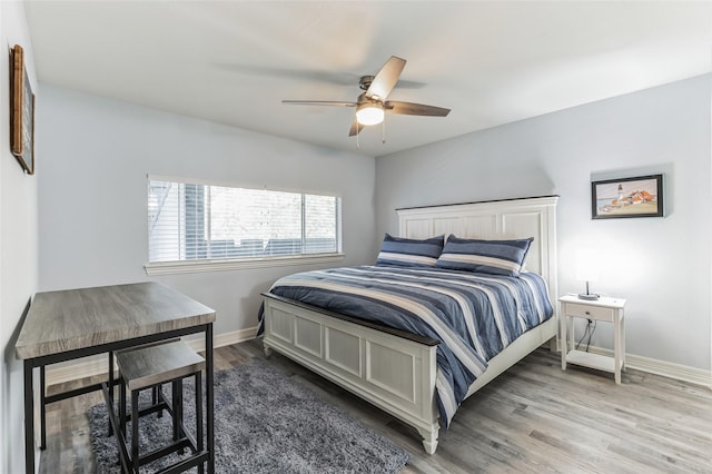 bedroom with a ceiling fan, baseboards, and wood finished floors