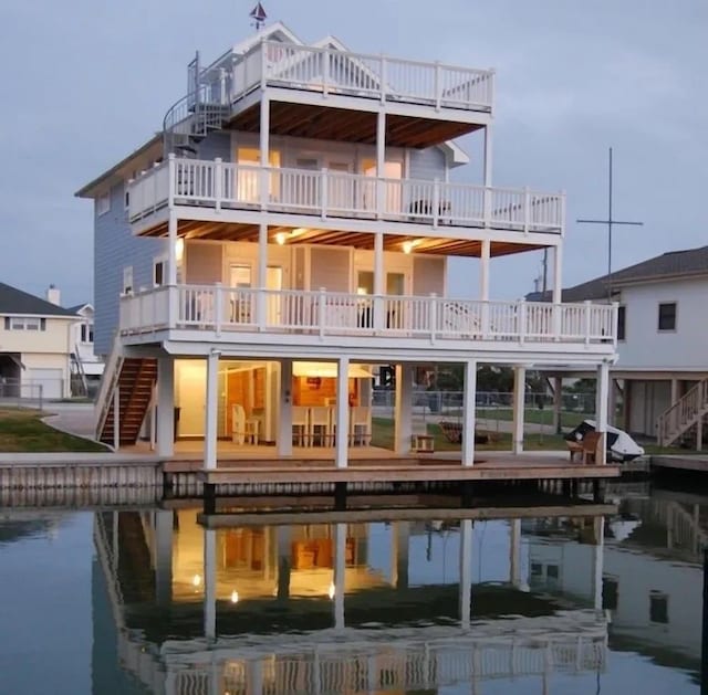 back house at dusk featuring a balcony