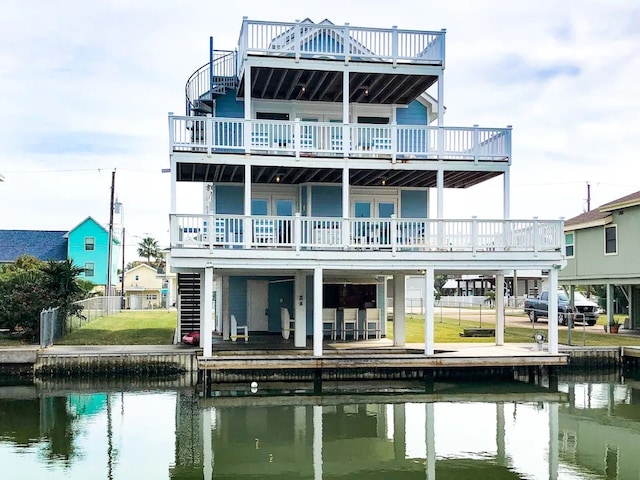 back of property with a balcony and a water view