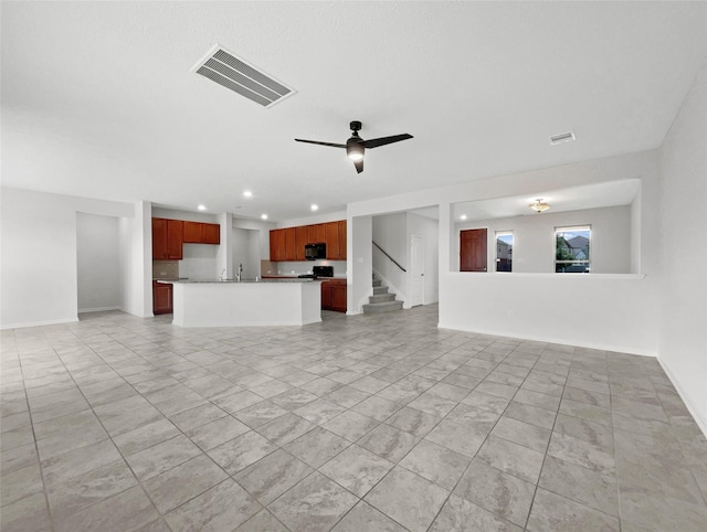 unfurnished living room with ceiling fan and sink