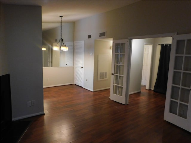 interior space with dark wood-type flooring, vaulted ceiling, and french doors