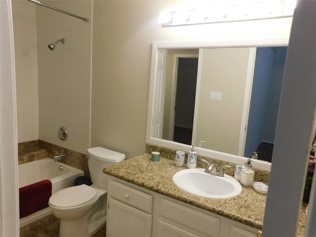 full bathroom featuring vanity, tiled shower / bath combo, and toilet