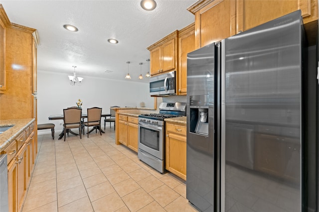 kitchen with stainless steel appliances, decorative light fixtures, light tile patterned floors, crown molding, and light stone countertops