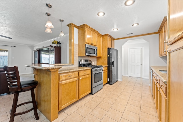 kitchen with stainless steel appliances, hanging light fixtures, ornamental molding, and plenty of natural light