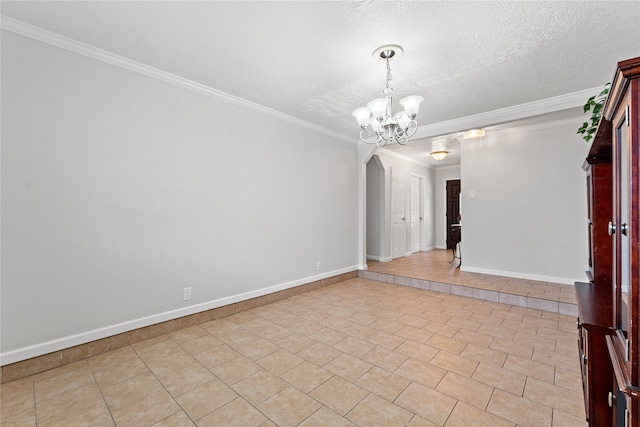 tiled empty room with a notable chandelier, a textured ceiling, and crown molding