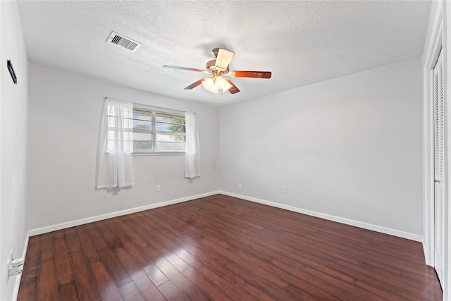 unfurnished room featuring dark wood-type flooring, a textured ceiling, and ceiling fan