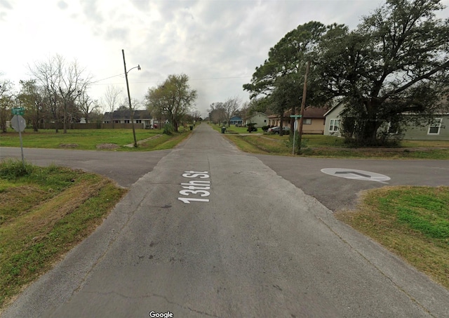 801 13th St, Port Arthur, TX 77640 - view of asphalt street featuring a residential view, traffic signs, and street lighting