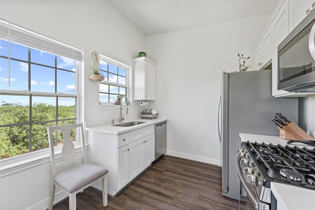 kitchen featuring appliances with stainless steel finishes, dark hardwood / wood-style flooring, sink, and white cabinetry