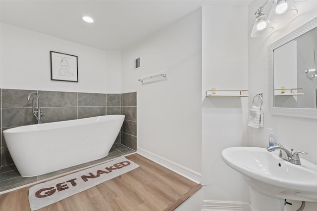 bathroom featuring tile walls, hardwood / wood-style floors, and sink