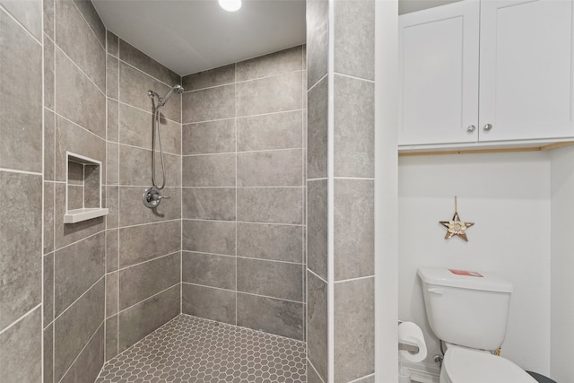 bathroom featuring tiled shower and toilet