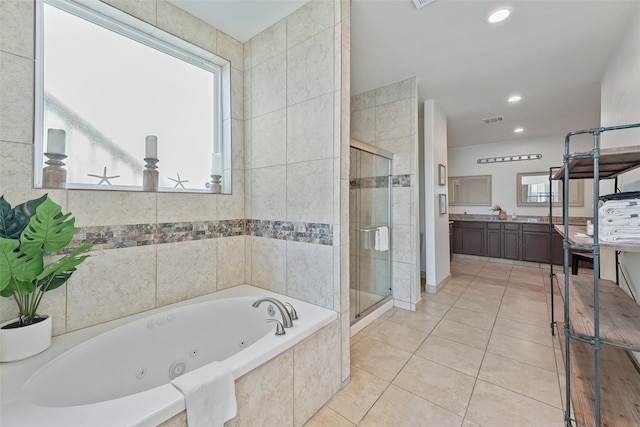 bathroom featuring shower with separate bathtub, tile walls, vanity, and tile patterned flooring