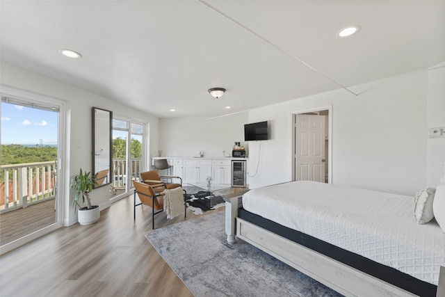 bedroom featuring wine cooler, light wood-type flooring, and access to outside