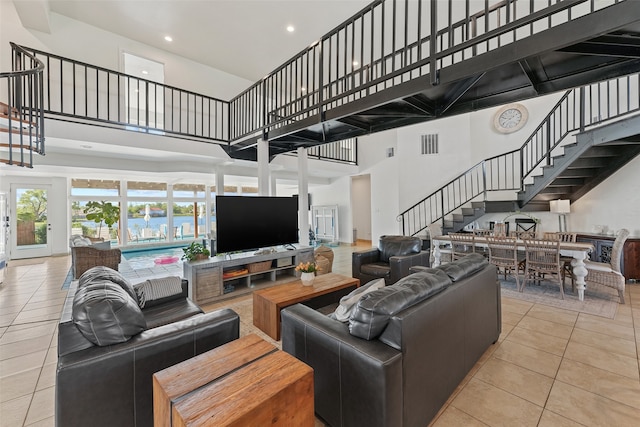 living room with light tile patterned floors and a towering ceiling