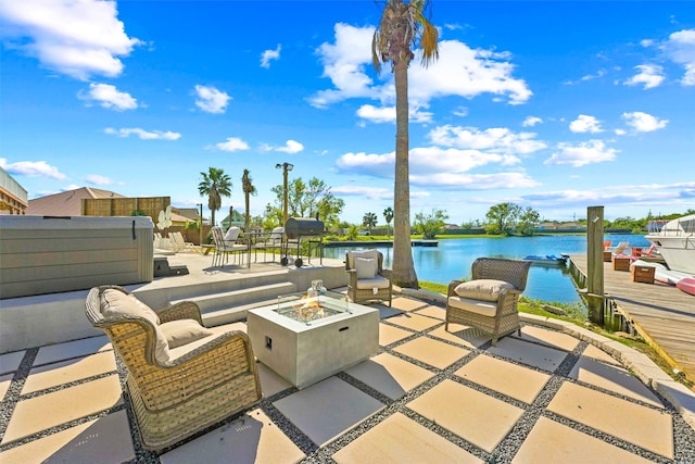 view of patio with a water view and an outdoor living space with a fire pit