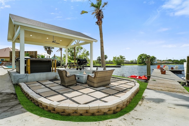 view of patio / terrace with a dock, ceiling fan, a water view, an outdoor hangout area, and a gazebo