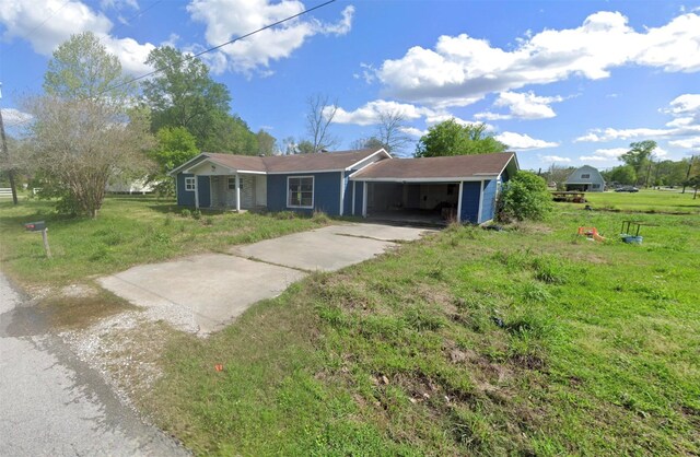 ranch-style home featuring a carport and a front yard