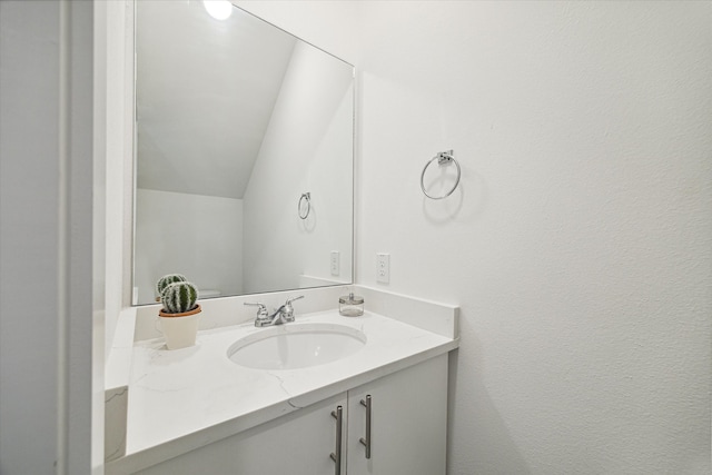 bathroom featuring vaulted ceiling and oversized vanity