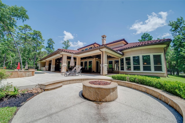 back of property featuring a patio and an outdoor fire pit