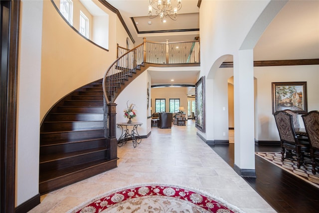 entrance foyer featuring a chandelier, a high ceiling, and ornamental molding