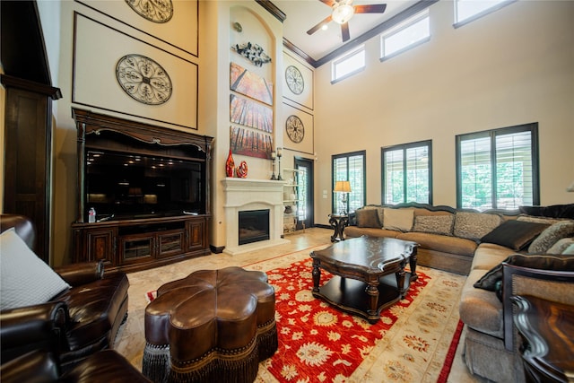 living room with ceiling fan and a towering ceiling