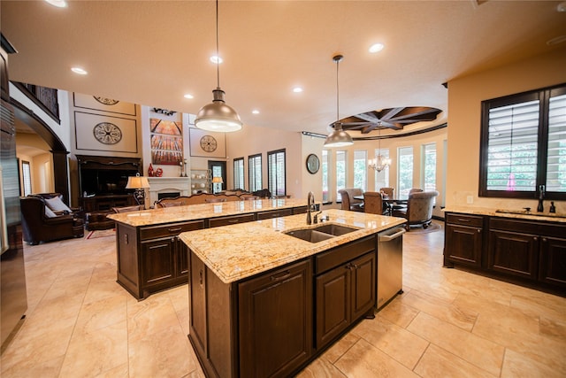 kitchen with coffered ceiling, a center island with sink, sink, hanging light fixtures, and beam ceiling