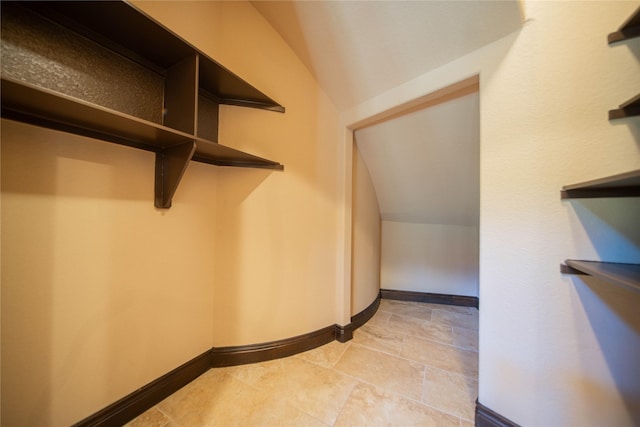 walk in closet with vaulted ceiling