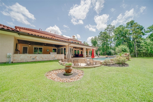 back of house with a patio, ceiling fan, and a lawn