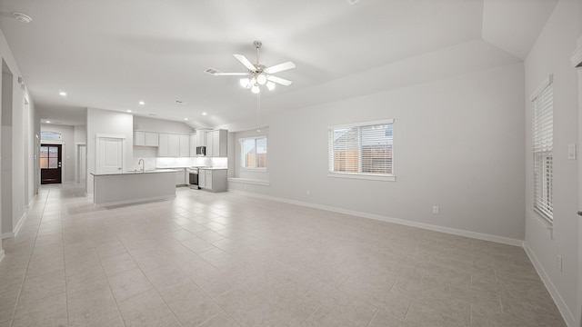 unfurnished living room with light tile patterned flooring, ceiling fan, lofted ceiling, and sink