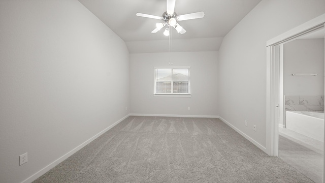 spare room featuring ceiling fan, light colored carpet, and lofted ceiling