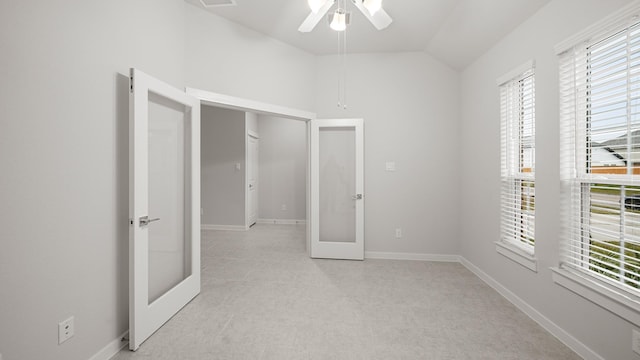 unfurnished bedroom with ceiling fan, vaulted ceiling, and french doors