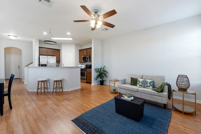 living room featuring light hardwood / wood-style floors and ceiling fan