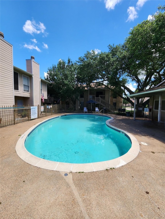 community pool featuring a patio area and fence