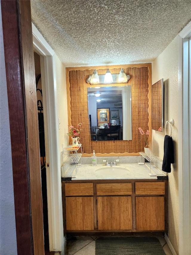 ensuite bathroom with a textured wall, a textured ceiling, vanity, and ensuite bath