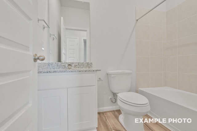 full bathroom featuring tiled shower / bath combo, hardwood / wood-style floors, toilet, and vanity