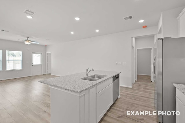 kitchen featuring stainless steel appliances, light hardwood / wood-style flooring, white cabinets, and sink