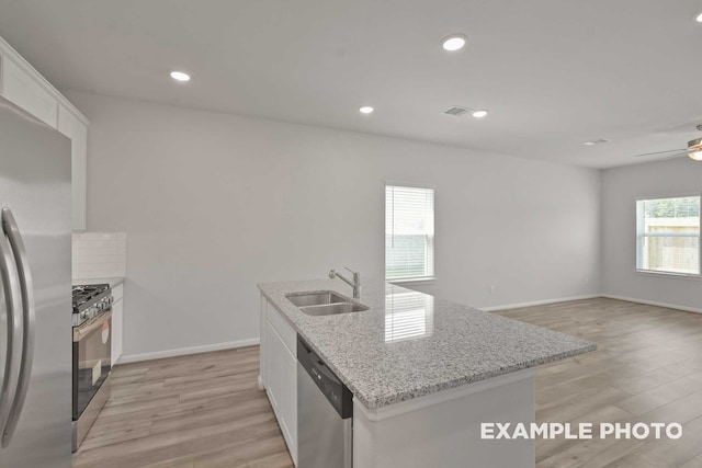 kitchen with ceiling fan, light wood-type flooring, white cabinets, sink, and appliances with stainless steel finishes