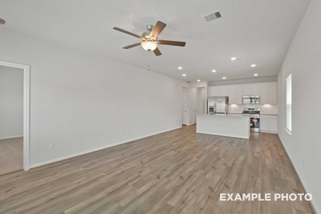 unfurnished living room with ceiling fan and light hardwood / wood-style flooring